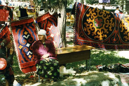 „A woman selling shyrdaks in Bishkek, Kyrgyzstan. “Shyrdak” means “collection of ornaments”, and is the standard floor covering for a yurt. They’re made of brightly dyed felt and don’t last for more than a few years, so they’re not expensive. I’ve read claims that they can last 30 or 40 years, and I have some that have lasted for 12 years, but I don’t put them on the dirt and walk on them in my shoes, either. Thirty years? Only with no kids, no dogs, no shoes“. Is borrowed from http://www.flickr.com/photos/jwpicht/3713408796/